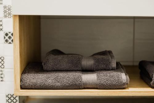 a pile of towels sitting on a shelf at Skylark - Singapore Penthouse with Jacuzzi & Panoramic View in Braşov