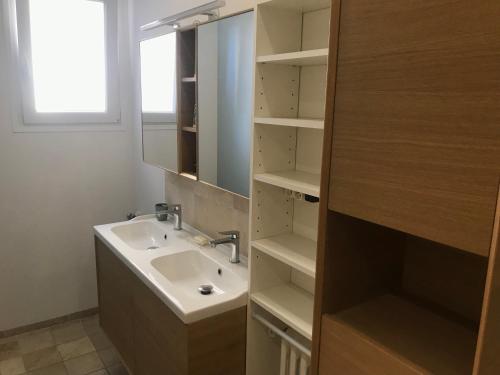 une salle de bain avec un lavabo et un miroir dans l'établissement Très bel appartement T3 proche place Castellane avec vue et 2 chambres, à Marseille