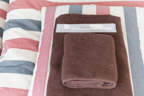 a pair of towels sitting on top of a bed at 大家族向け貸切宿 敷地内無料駐車場 最高のロケーション 各階独立鍵付き個室 Paradise inn牧志 in Naha