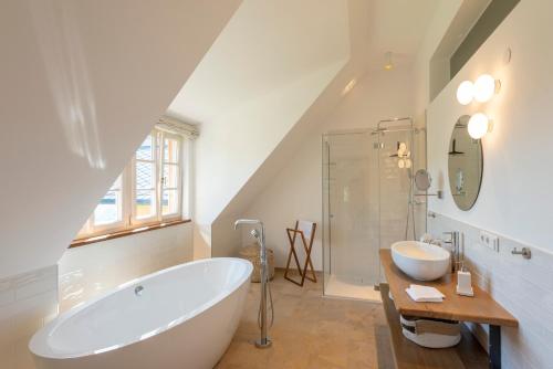 a bathroom with a large white tub and a shower at Landhaus Obersteinriegl in Gaflenz