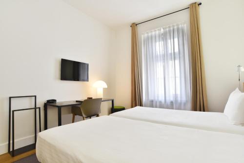 a hotel room with a bed and a desk at Hotel Zenit Budapest Palace in Budapest