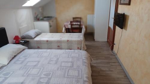 une chambre avec deux lits et une télévision dans l'établissement il monolocale, à Turin