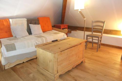 ein Schlafzimmer mit einem Bett, einem Tisch und einem Stuhl in der Unterkunft Les Pins - Maison avec parking ferme et jardin commun au calme in Saint-Prix