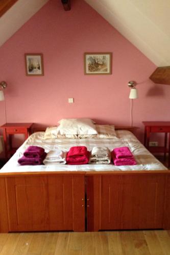ein Schlafzimmer mit einem großen Bett mit rosa Wänden in der Unterkunft Les Pins - Maison avec parking ferme et jardin commun au calme in Saint-Prix