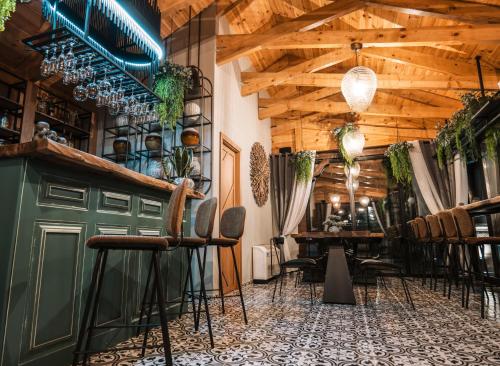 eine Bar mit Stühlen und Tischen in einem Zimmer mit Holzdecken in der Unterkunft Vila Helen in Voskopoja