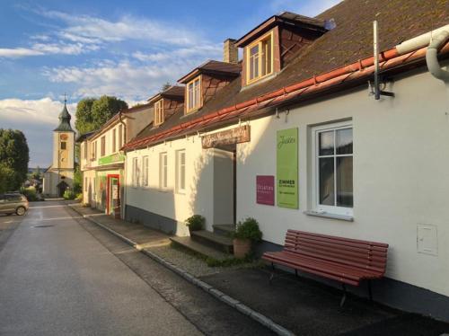 a bench sitting outside of a building on a street at Bühnenwirtshaus Juster in Gutenbrunn