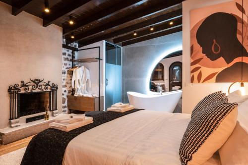 a bedroom with a large bed with a fireplace and a tub at Vila Helen in Voskopojë