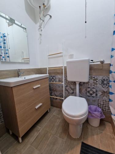 a bathroom with a toilet and a sink and a mirror at Casa Geloso in Ustica