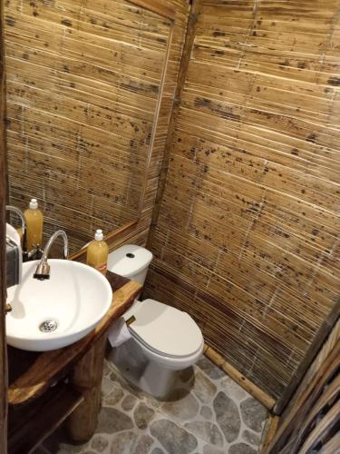 a bathroom with a white toilet and a sink at HakunaMatata glamping Pumba in Salento