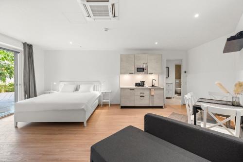 ein weißes Schlafzimmer mit Bett und Küche in der Unterkunft VibeStudio 405 - Central - AC - Licensed - Parking Nearby in Wien