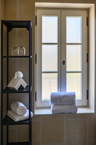 Cette chambre dispose d'une fenêtre et d'une pile de serviettes. dans l'établissement Villa Sainte Anne, à Gigondas