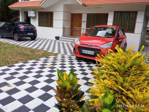 a red car parked in front of a house at Devi Kripa Residency in Varkala
