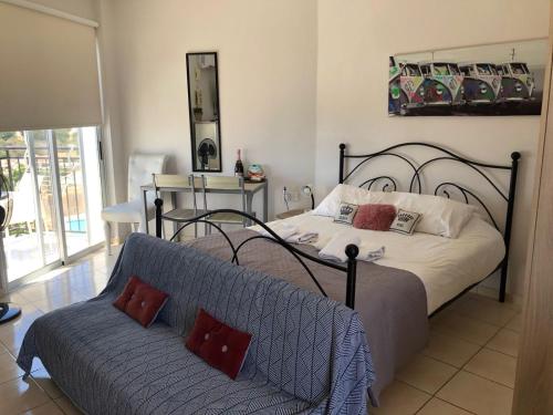 a bedroom with a bed and a couch at Panoramic Holidays - Standard 50 in Peyia