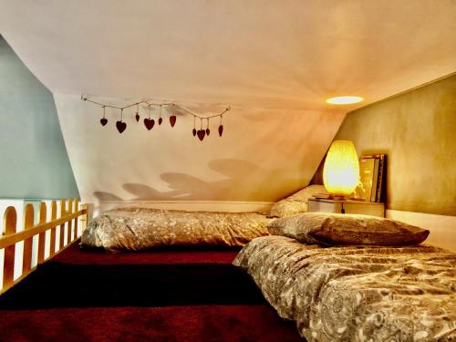 sypialnia z 2 łóżkami i stołem z lampką w obiekcie La cabane des coteaux w mieście Gan