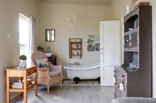 ein Badezimmer mit einer Badewanne und einem Stuhl in der Unterkunft Green Gables Country Inn in McGregor