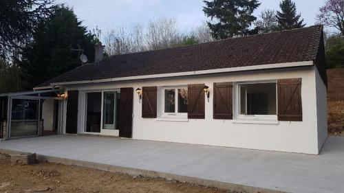 een klein wit huis met een grote patio bij villa skys France in Gien