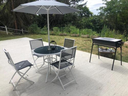 - une table, des chaises et un parasol sur la terrasse dans l'établissement villa skys France, à Gien