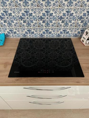 a kitchen counter with a stove with a black mat at Residence Le Maree in Porto Pino