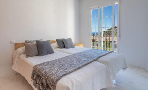 1 dormitorio con 2 camas y ventana grande en Blue Luxury Apartment en La Herradura