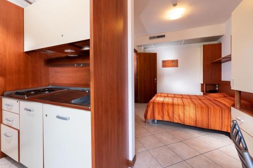 eine Küche und ein Schlafzimmer mit einem Bett in einem Zimmer in der Unterkunft Hotel Sheila in Lido di Jesolo
