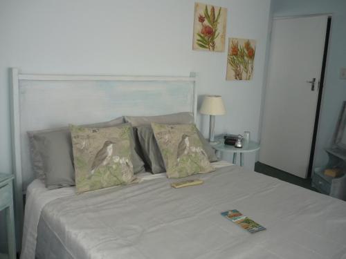 a bed with two pillows and a book on it at A1 Kynaston Guest House bed and breakfast or self catering in Jeffreys Bay