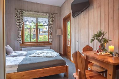 a bedroom with a bed and a desk and a table at Pokoje Samo Centrum in Zakopane