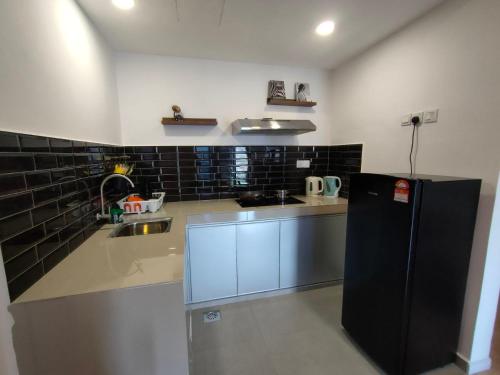 eine Küche mit Kühlschrank und Spüle in der Unterkunft SunKissed Paradise @ Marina View Villas PD in Port Dickson