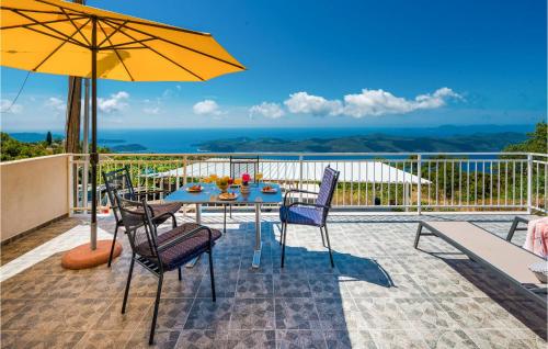 a table with chairs and an umbrella on a patio at Pet Friendly Apartment In Dubravica in Dubravica