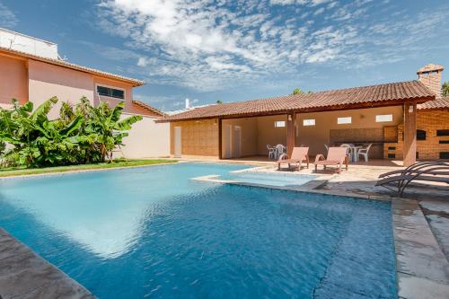 a swimming pool in the backyard of a house at SAN GIACOMO I Apartamentos por Temporada para amigos, famílias e empresas no Porto das Dunas - Ceará in Aquiraz