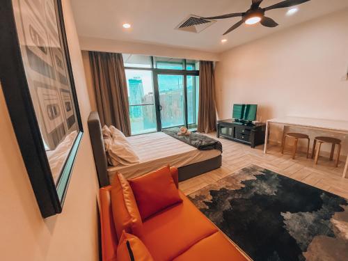 a bedroom with a bed and a couch and a tv at Crown9 Suite (Sunset & City View)@Empire City in Petaling Jaya