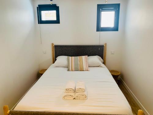 a bed with two slippers on it with two windows at EL PEPITA, Sublime maison de ville, Rennes in Rennes