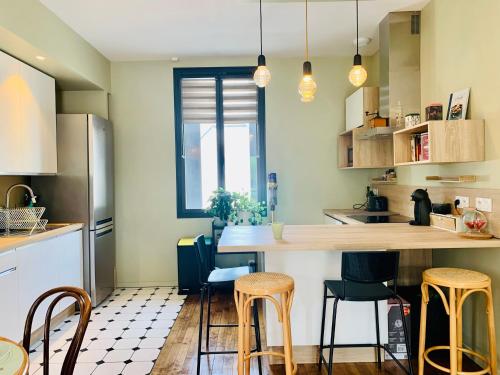 une cuisine avec un comptoir et quelques tabourets dans l'établissement EL PEPITA, Sublime maison de ville, Rennes, à Rennes