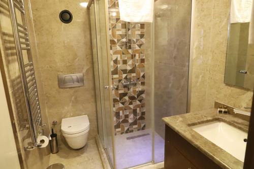 y baño con ducha, aseo y lavamanos. en HİTİT OTEL, en Ankara