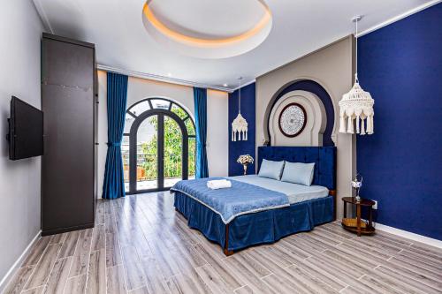 a blue bedroom with a bed and a window at T-Maison Riad Villa, with Pool, Karaoke, Billiards, near beach, Vung Tau in Vung Tau