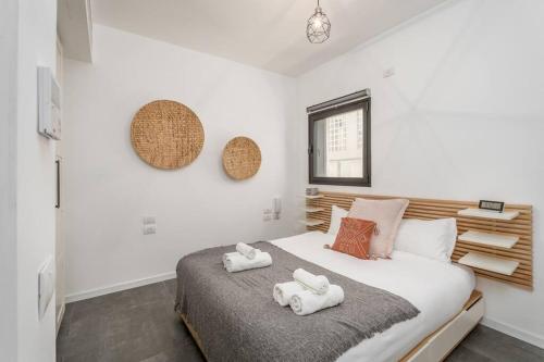 1 dormitorio con 1 cama con toallas en Gordon Area - Amazing one BDR close to the beach en Tel Aviv