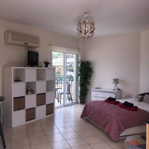 a bedroom with a bed and a chandelier at Panoramic Holidays - Standard 73 in Peyia