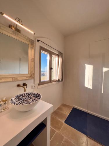 a bathroom with a sink and a glass shower at Masseria OSTUNI MARE Agri Resort in Ostuni