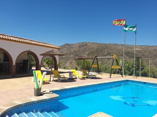 una piscina con sillas y una cometa volando sobre ella en Benavilla en Albuñol