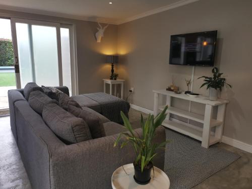 a living room with a couch and a tv at Gray Cottage in Strand