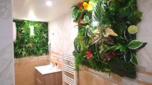 een badkamer met een groene muur met planten bij SAUNA Appartement 10mn Aeroport Roissy CDG in Villeneuve-sous-Dammartin