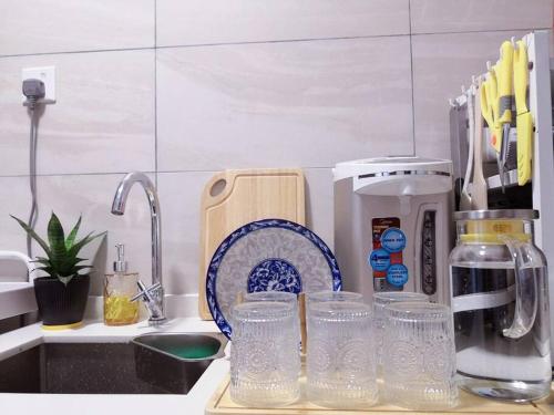 a kitchen counter with glasses on a counter top at Hanns&KingBed&WIFI&Pool& Parking&Sauna&Sunshine Classic Comfort Homstay in Sibu