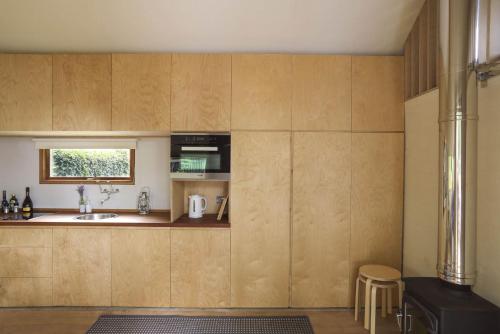 a kitchen with wooden cabinets and a sink and a window at The BoatShed in Lymington