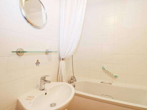 a bathroom with a sink and a tub and a mirror at Flat 33 - Marine Court in Littlehampton