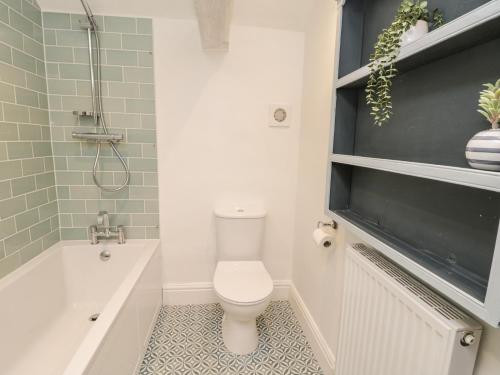a bathroom with a toilet and a tub and a sink at Cliff House in York