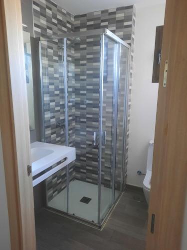 La salle de bains est pourvue d'une douche en verre et d'un lavabo. dans l'établissement Sol y Luz 2, à Caleta de Fuste