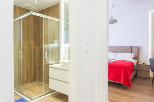 a bedroom with a shower and a bed with a red blanket at New modern style home next to the train station in Thessaloniki