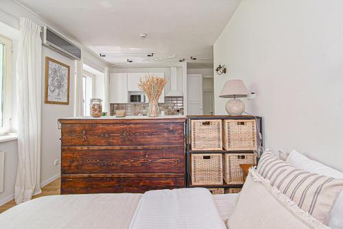 1 dormitorio con tocador de madera y sofá en Cozy Studio in the heart of Vilnius Old Town, en Vilna