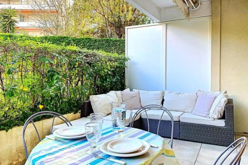 una mesa con platos y vasos en el patio en HENRI CAMILLE REAL ESTATE - GOLDEN - one bedroom apt swimming pool, en Cannes