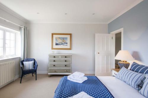 a bedroom with a blue and white bed and a dresser at The Old Post Office in Lymington