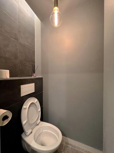 La salle de bains est pourvue de toilettes avec une lumière au-dessus. dans l'établissement Cosy 1 bedroom Appt Proche de tout Metro à pied, à Boulogne-Billancourt